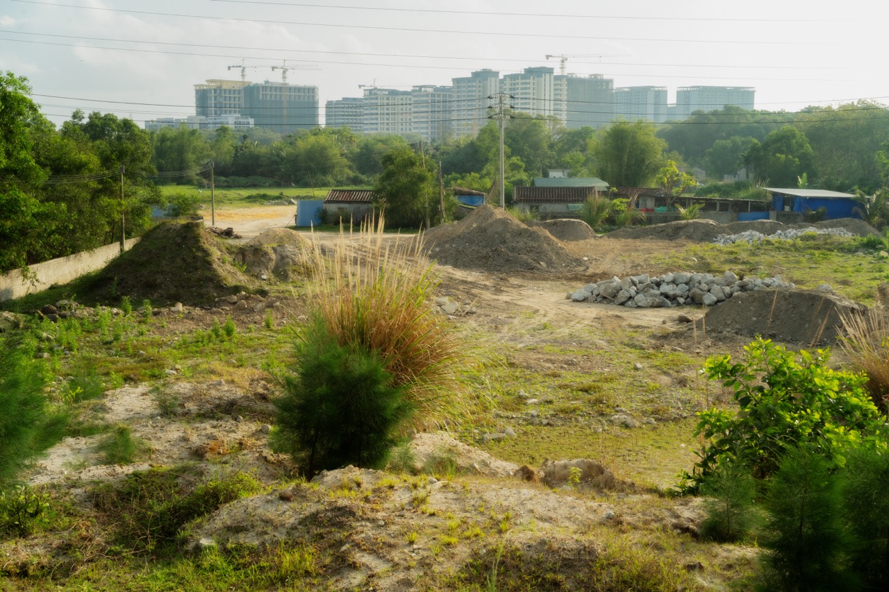 Construction wasteland with rising towers in background